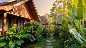 a path leading to a house in a garden at The Woods Uluwatu in Uluwatu