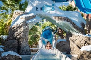 a child riding a water slide at the blue turtle water park at Oasis Blue Resort - Hotel & Residenz Apartments Strandnähe in Caorle