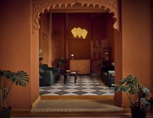 a lobby with couches and a table on a checkered floor at Minimalist - Lake Pichola Edit in Udaipur