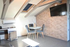 a dining room with a table and chairs and a brick wall at San Mauro rooms in Poreč