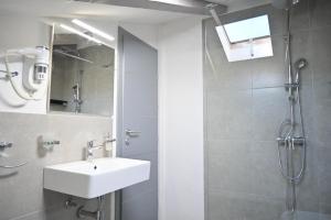 a bathroom with a sink and a shower at San Mauro rooms in Poreč +32 photos
