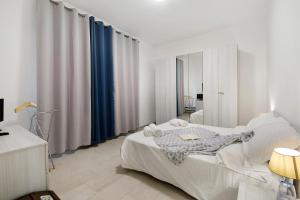 a white bedroom with a bed and a mirror at Appartamento Zia Nena in Zelo Buon Persico