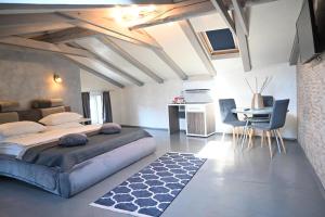 a bedroom with a large bed and a table and chairs at San Mauro rooms in Poreč