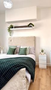 ein Schlafzimmer mit einem großen Bett und grünen Kissen in der Unterkunft Cloud Quarters 3 in Amley