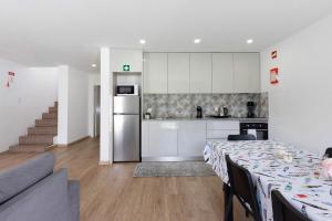 a kitchen and living room with a table with a table cloth at Manuel'shouse in Vila Nova de Gaia