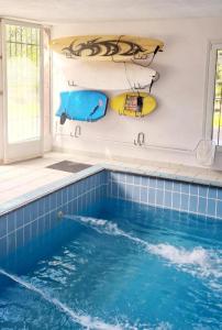 a swimming pool with surfboards on the side of a house at VILLA ISLAS Urdaibai in Isla Becoa
