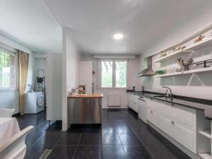 a large kitchen with white cabinets and a sink at VILLA ISLAS Urdaibai in Isla Becoa