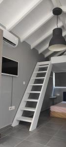 a loft bed with a staircase in a room at Lea's Studio in Kourouta