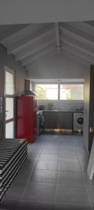 a large kitchen with a red refrigerator and a stove at Lea's Studio in Kourouta