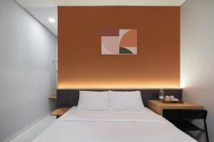 a bedroom with a bed and a painting above it at Cove Vaia in Bandung +16 photos