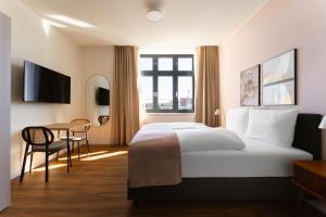 a hotel room with a bed and a table at Limehome Gelsenkirchen Hochstr in Gelsenkirchen