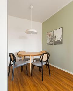 a dining room table with four chairs and a light fixture at Limehome Gelsenkirchen Hochstr in Gelsenkirchen +32 photos