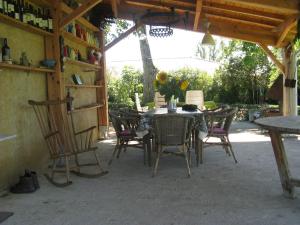 una mesa y sillas sentadas bajo una estructura de madera en Maison Dufraing - Anan, en Anan