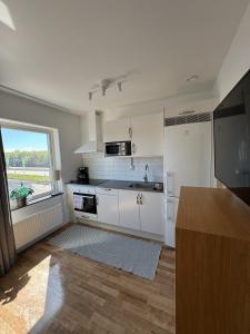 a kitchen with white appliances and a large window at Apartments Lund in Lund