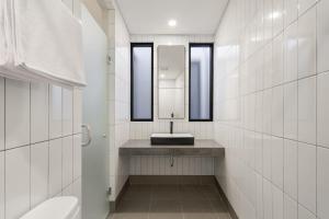 a bathroom with a sink and a mirror at Cove Vaia in Bandung