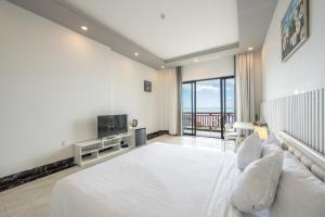 a bedroom with a large white bed and a television at Casa De Sol Resort - Wuwei Retreat in Phú Quốc