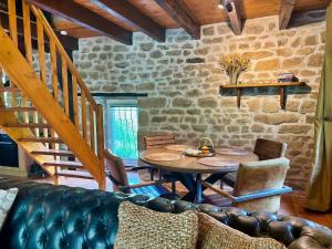 a living room with a table and a couch at Le Gîte de Couturas in Saint-Hilaire-les-Courbes