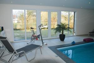 a room with a swimming pool and a gym with a treadmill at Haus Sonnenwinkel in Bad Laer