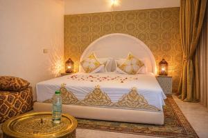 a bedroom with a white bed with gold patterns at Hotel Larayhana in Fez