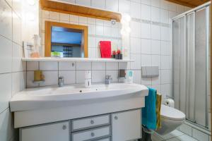a white bathroom with a sink and a toilet at Landler Auszeit in Thiersee +87 photos