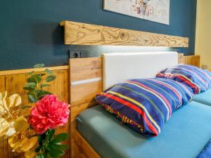 a bed with two pillows and a flower on it at Landler Auszeit in Thiersee
