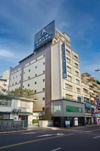 a building with a sign on the top of it at K Hotel Keelung in Keelung
