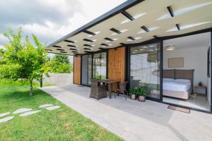 a glass house with a bed and a desk on a patio at Morera Suite Paliouri in Paliouri +4 photos
