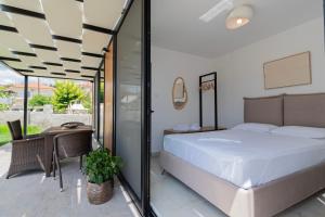 a bedroom with a bed and a balcony at Morera Suite Paliouri in Paliouri