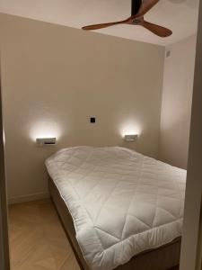 a bedroom with a bed with a ceiling fan at Duin & Zee in Ostend