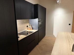 a kitchen with black cabinets and a counter at Duin & Zee in Ostend +10 photos