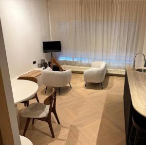 a living room with tables and chairs and a television at Duin & Zee in Ostend