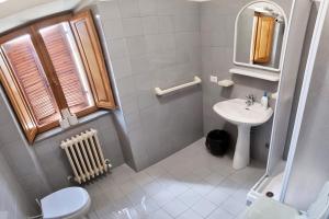 a bathroom with a sink and a toilet and a mirror at Ostello del Parco di Monte Cucco in Costacciaro +26 photos