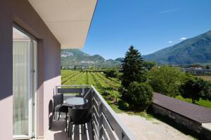 a balcony with a table and chairs and a view at Rolly - Rooms & Restaurant in Riva del Garda