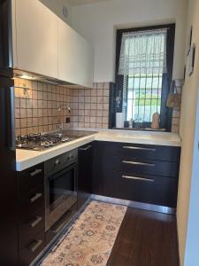 a kitchen with black cabinets and a sink and a window at Nice Gecko in Baveno