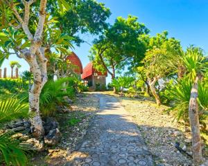 a path through a garden with trees and a building at Sea Cliff Eco Nusa Penida in Polilit
