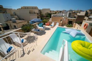 a swimming pool on the roof of a building at The White Knight Premium Boutique Hotel in Għajnsielem