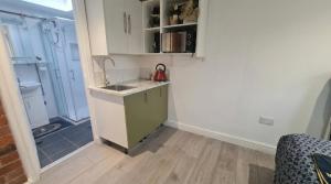 a small kitchen with a sink and a shower at 1 Bedroom studio in Datchet