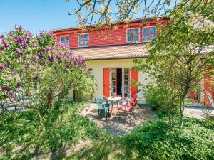 a red and yellow house with a table and chairs at Feriendorf Rugana - Klassik 1-Raum Ferienwohnung mit Terrasse B59 in Dranske