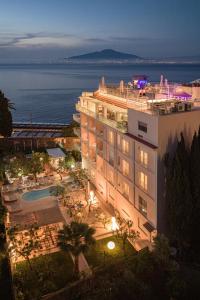 a view of a building with the ocean in the background at Boutique Hotel Regina in Sorrento