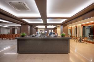 a lobby with a large island in the middle at Oya Beach Resort in Hersonissos +63 photos