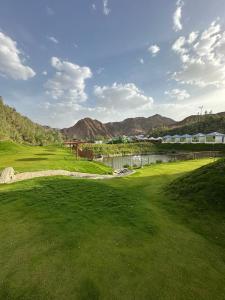 a view of a golf course with mountains in the background at منتجع خيال رفيف in Ḩarshaf