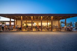 a group of people sitting at tables on a patio at Oya Beach Resort in Hersonissos