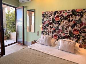 a bedroom with a large bed with a floral wall at Rozmari Suites in Agia Galini