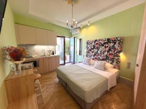 a bedroom with a large bed and a kitchen at Rozmari Suites in Agia Galini