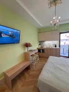 a room with a kitchen with a bed and a tv on the wall at Rozmari Suites in Agia Galini +10 photos