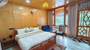 a bedroom with a bed and a blue chair at Bhaderwah Resorts Pvt Ltd in Dranga