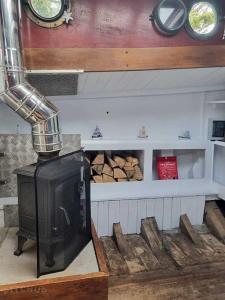 a kitchen with a stove and some logs at The Ship Aground Woolacombe in Woolacombe