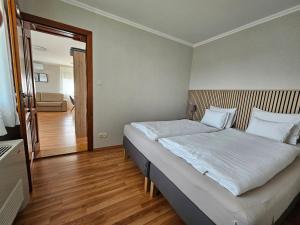 a bedroom with a large white bed in a room at Elek Apartmanház in Hajdúszoboszló