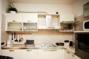 a kitchen with white cabinets and a sink at Guest House Sassuolo 2 in Sassuolo +13 photos
