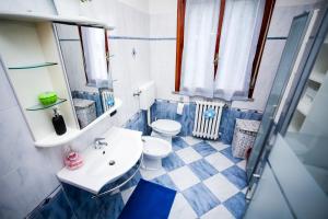 a blue and white bathroom with a toilet and a sink at Guest House Sassuolo 2 in Sassuolo